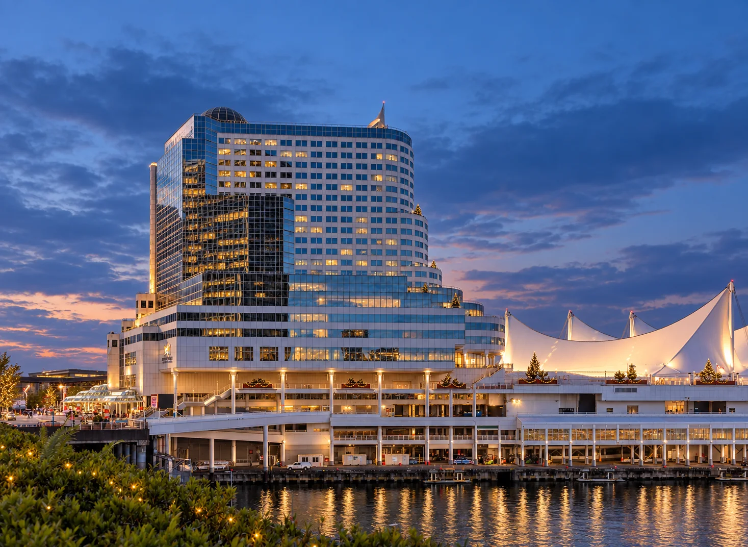 Canada Place sails and waterfront in Downtown Vancouver under a cloudy sky